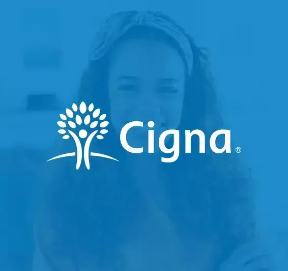 Blue-tinted photo of a woman with curly hair overlaid with the Cigna logo.