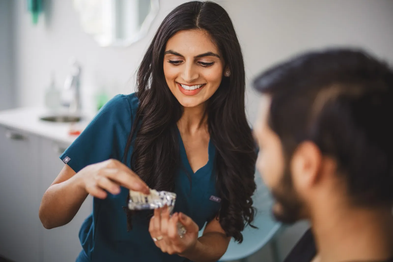 Dr. Zaidi showing a patient a smile model in the Clarksburg office