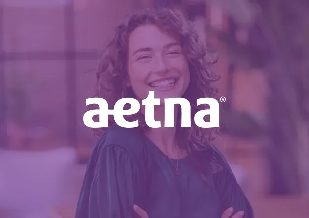 Smiling curly-haired woman with arms crossed behind the white 